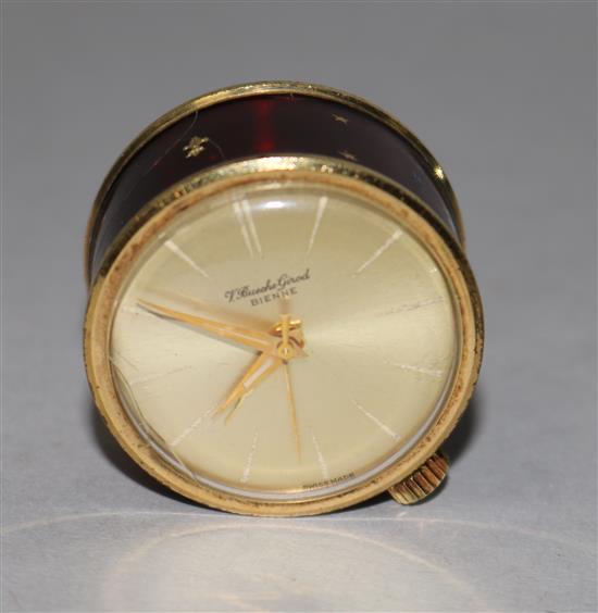 A mid 20th century V. Bueche Girod Bienne gilt metal and enamel travelling musical alarm drum shaped clock (a.f.), diameter 29mm.